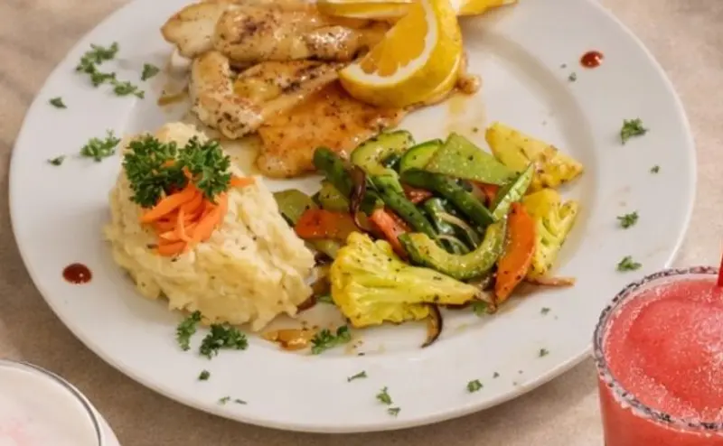 Plato con pollo a la plancha, ensalada y vegetales salteados