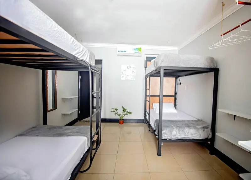 Dormitorio compartido con camarotes de madera oscura y ropa de cama blanca