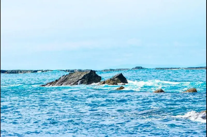 Rocas que sobresalen del agua turquesa frente a la costa