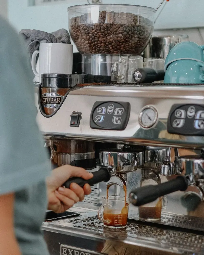 Máquina de espresso con portafiltros y molino con granos de café