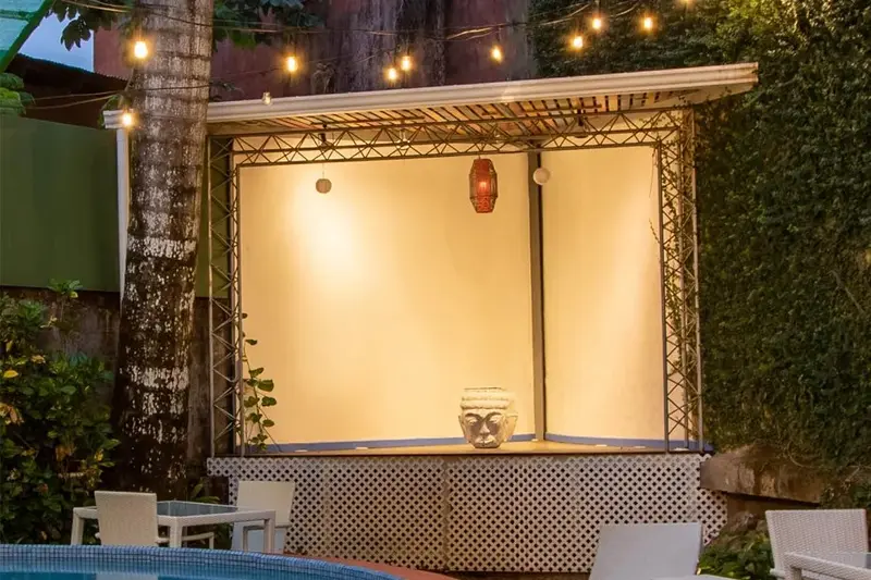 Escenario para música en vivo junto a la piscina, con luces colgantes