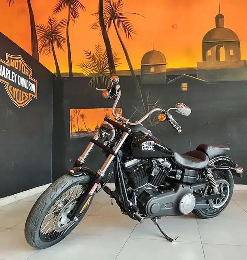 Harley-Davidson Street Bob negra frente a un mural de atardecer