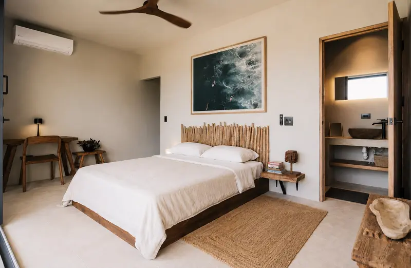 Habitación con cama king, cabecera de cañas, ventilador de techo y baño privado