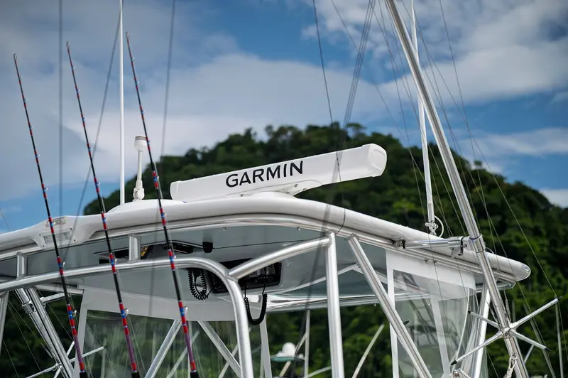 Torre del barco con antena Garmin y cañas de pesca contra el cielo