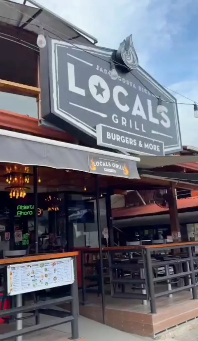 Fachada de Locals Grill sobre la avenida principal de Jacó