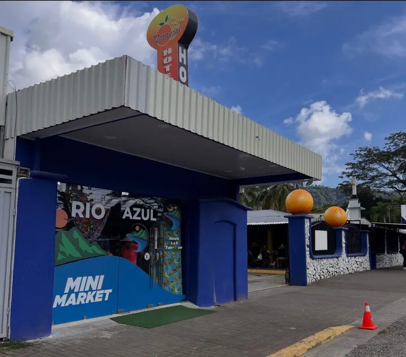 Entrada del hotel con techo azul y el minisúper