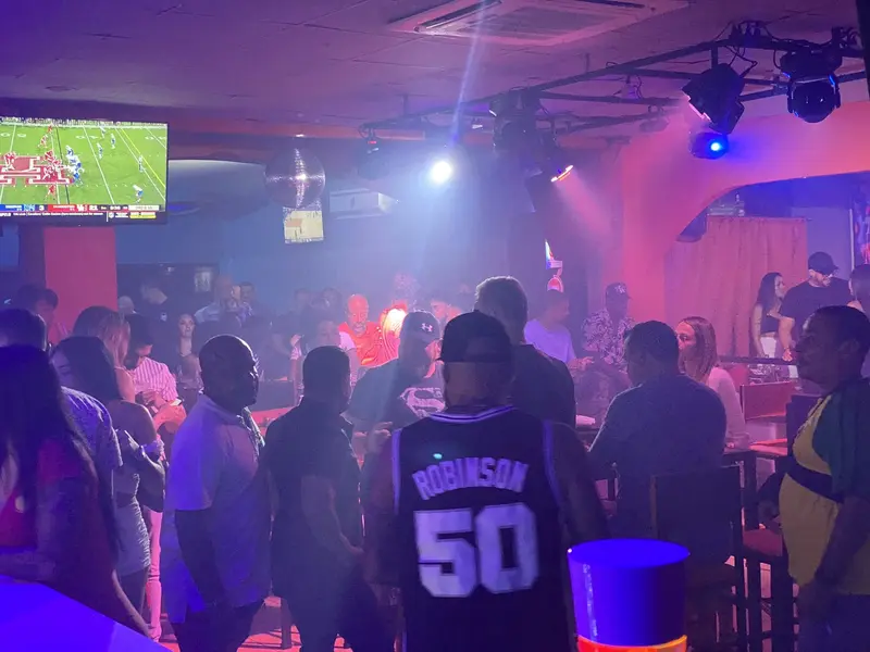 Salón con pista de baile, pantalla de televisión y luces de colores