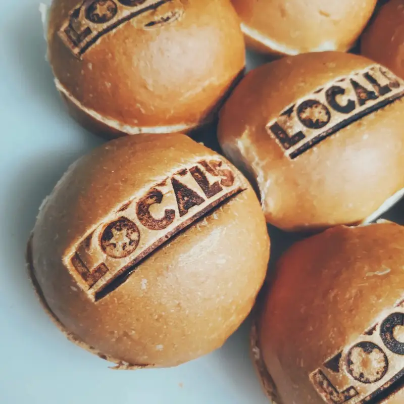 Panes de hamburguesa con el logo de Locals Grill marcado a fuego