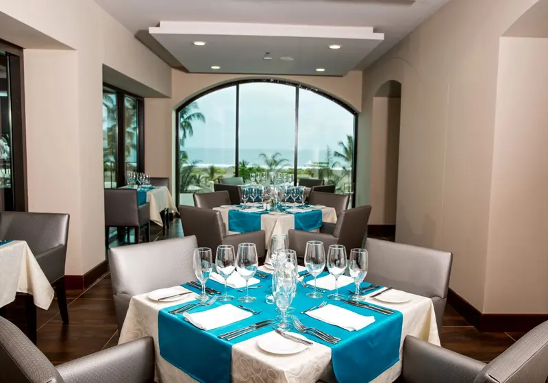 Comedor del restaurante con mesas servidas y ventanal