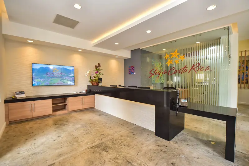 Recepción de la oficina con mostrador y el logo de Stay in Costa Rica en el vidrio
