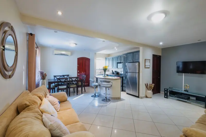 Sala y comedor de la Casa Toucan, con sofá, mesa de comedor y cocina al fondo