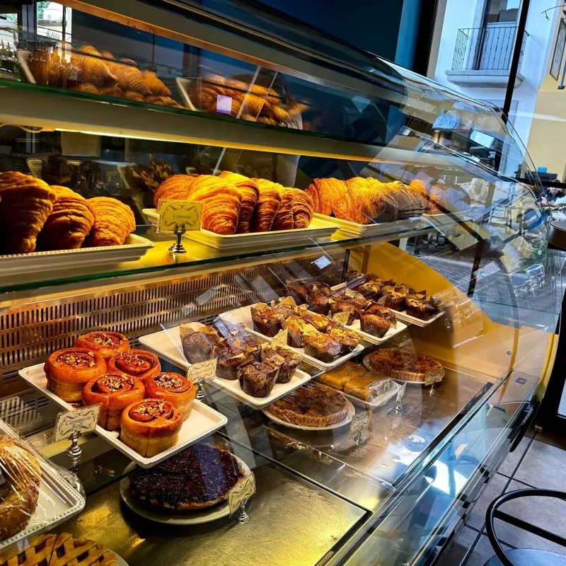 Vitrina de panadería con croissants y repostería