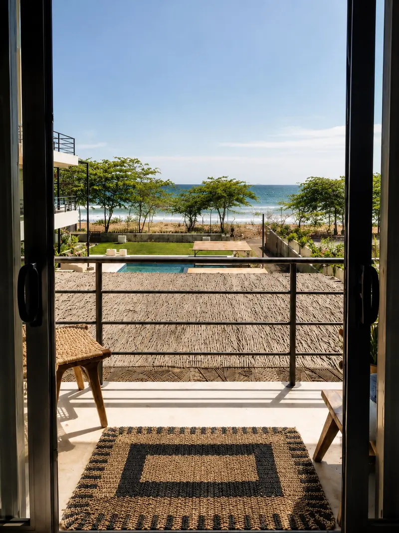 Vista al mar desde el balcón de una habitación, con la piscina y el jardín debajo