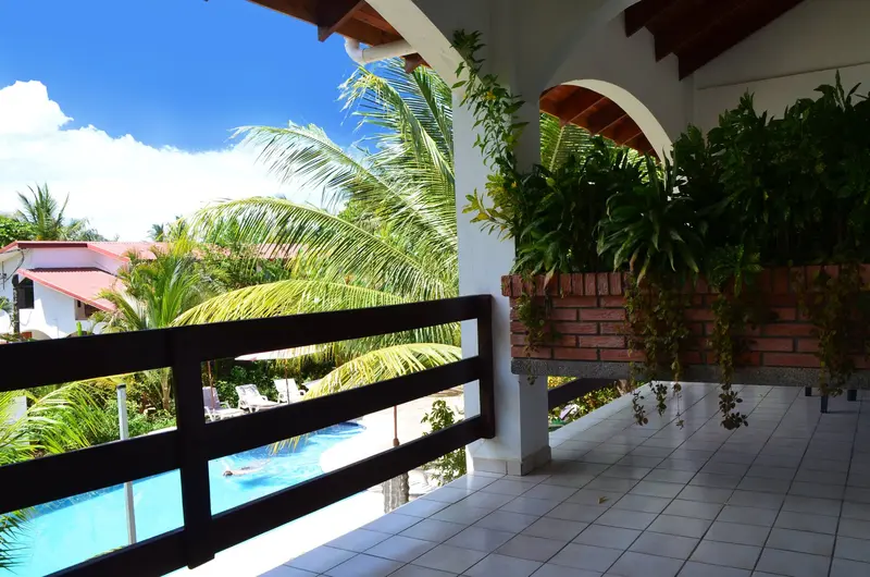 Terraza del segundo piso con barandas de madera y vista a la piscina