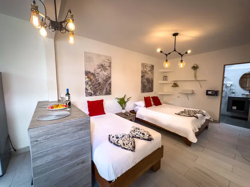 Habitación con dos camas, lámparas colgantes y una barra de cocina