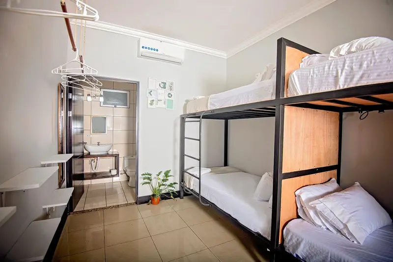 Dormitorio con dos camarotes, baño al fondo y piso de cerámica