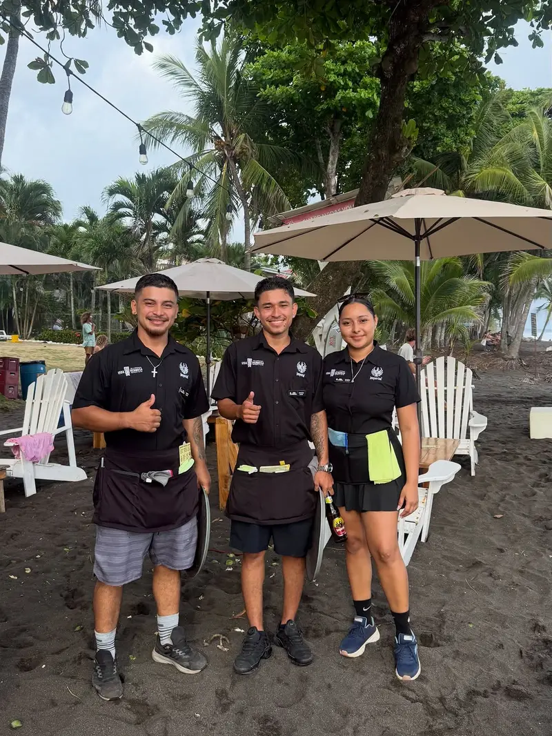 The Vida Hermosa team on the beach, with the lounge chairs and umbrellas behind them