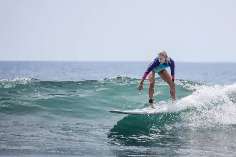 Surfista sobre una ola en el mar con espuma blanca