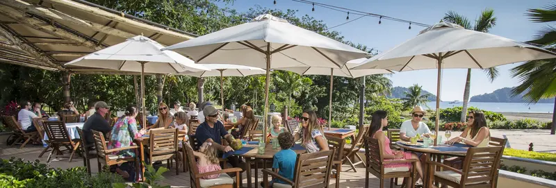 Terraza de restaurante con sombrillas frente a la marina