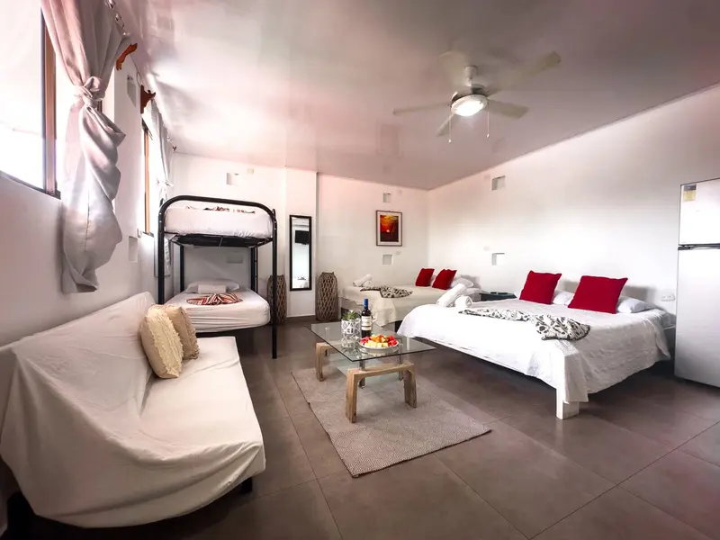Habitación familiar con cama matrimonial, litera y un sillón