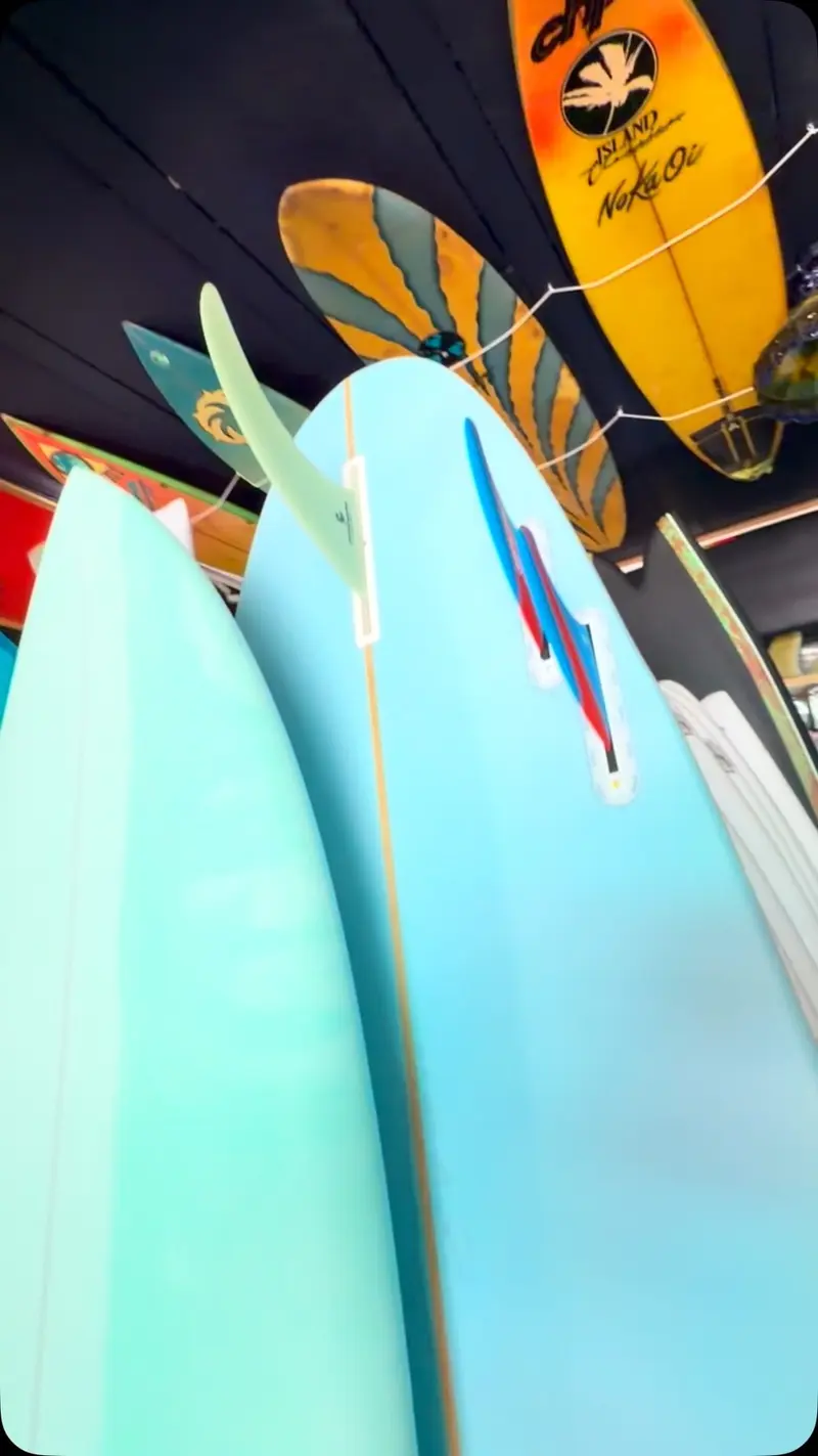 Tablas de surf azul celeste apoyadas una junto a otra dentro del taller