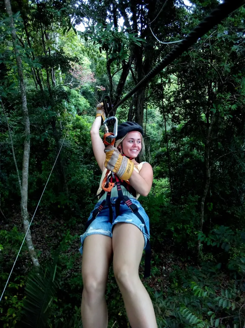 Guest riding a zipline through the foliage