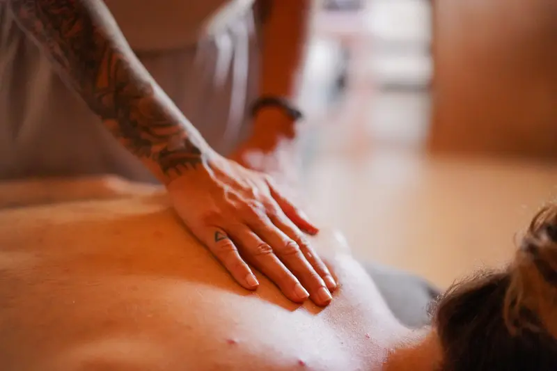 Manos de la terapeuta sobre la espalda de una persona durante una sesión