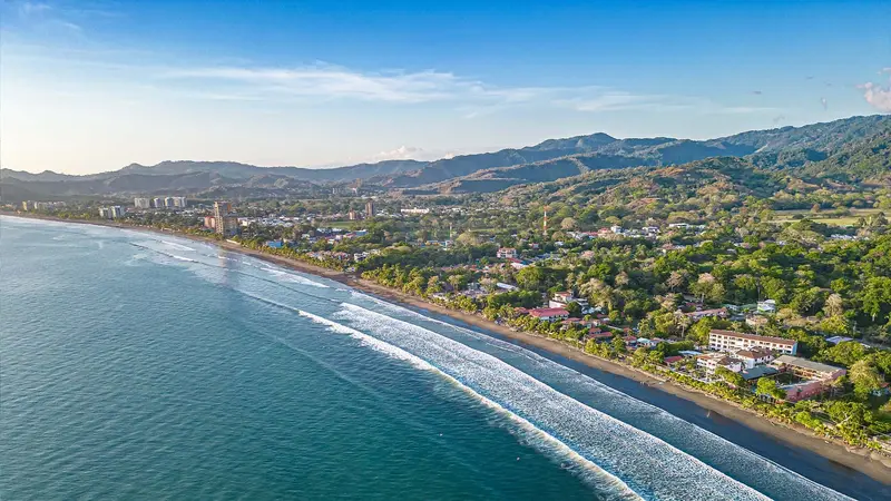 Vista aérea de la playa de Jacó y la ciudad al pie de las montañas
