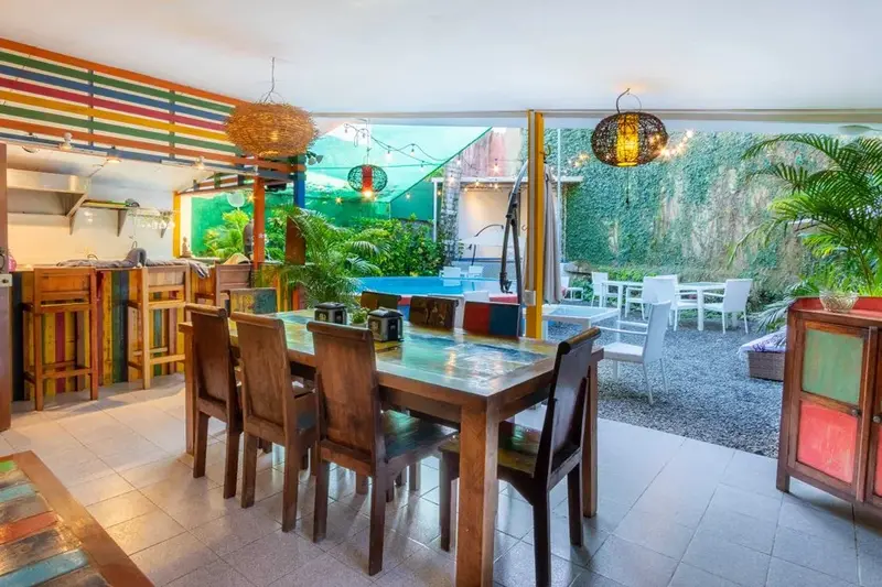 Comedor con mesa de madera abierto al jardín y la cocina