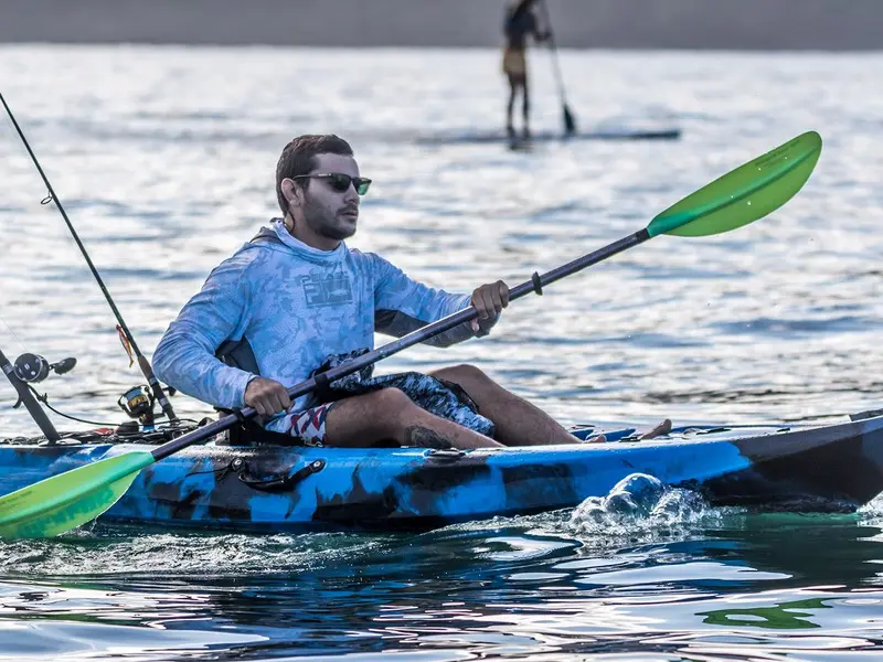 Kayakista remando con una paleta verde