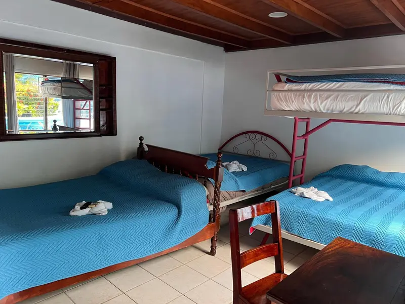 Habitación con camarote, camas de colcha azul y escritorio de madera