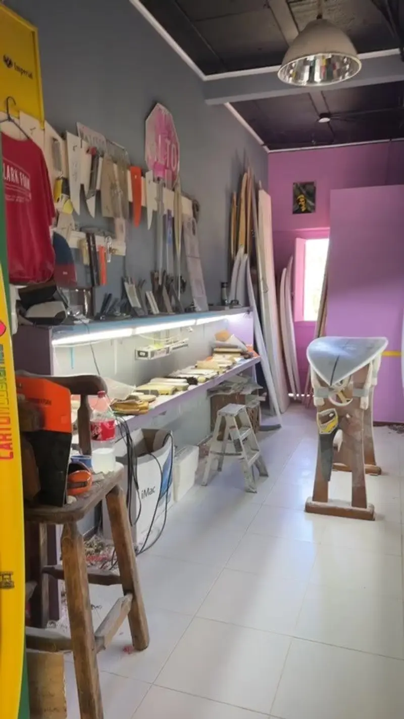 Interior de la tienda con tablas y accesorios en estantes y una mesa de trabajo