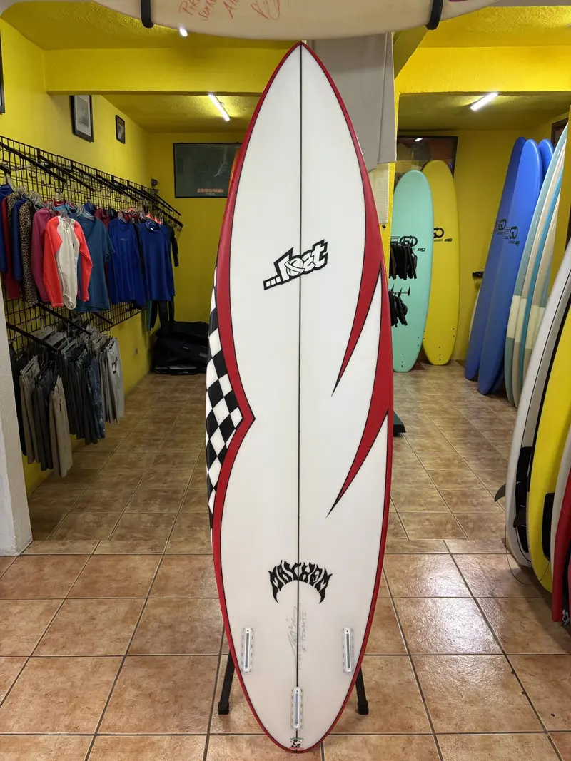 Tabla Lost blanca con borde rojo y diseño de cuadros en un soporte dentro de la tienda