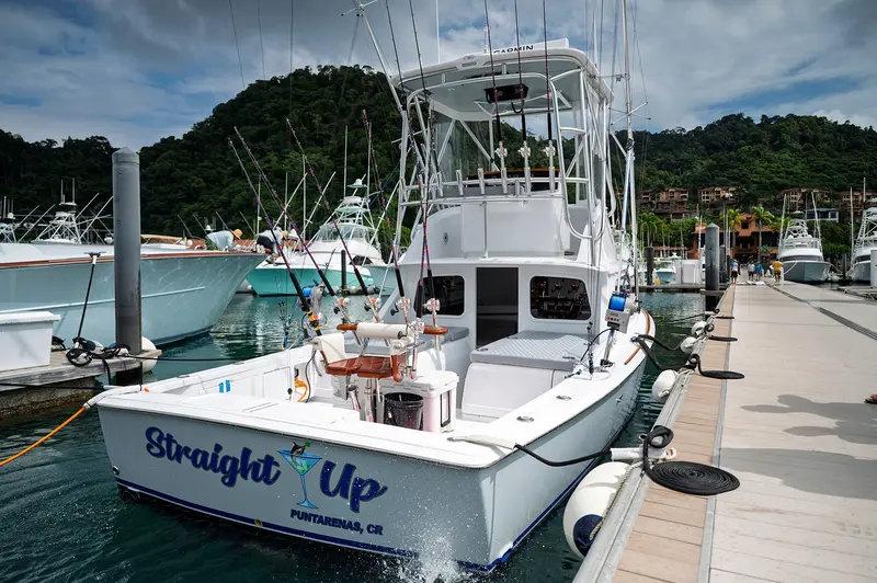 Barco de pesca Straight Up amarrado en un muelle de la marina, con su nombre en el casco