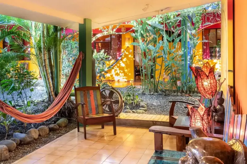 Rincón de descanso con hamaca, silla de madera y plantas