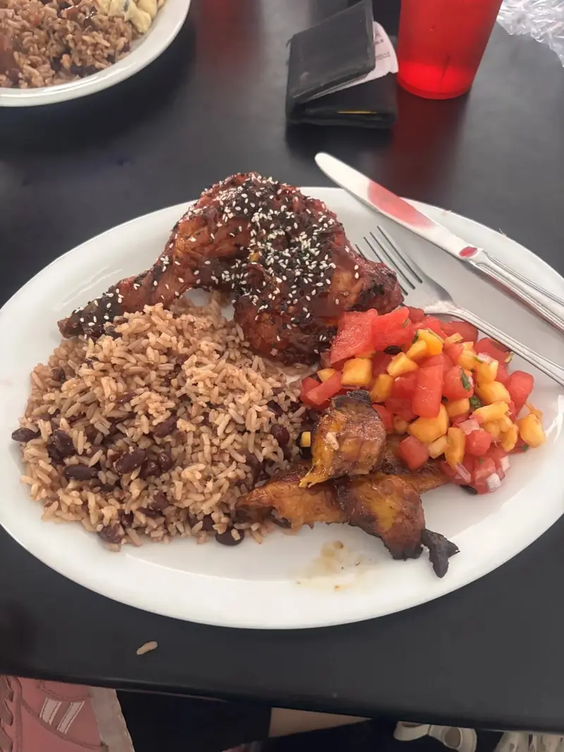 Plato con pollo glaseado con ajonjolí, arroz con frijoles, plátano frito y ensalada de pimientos