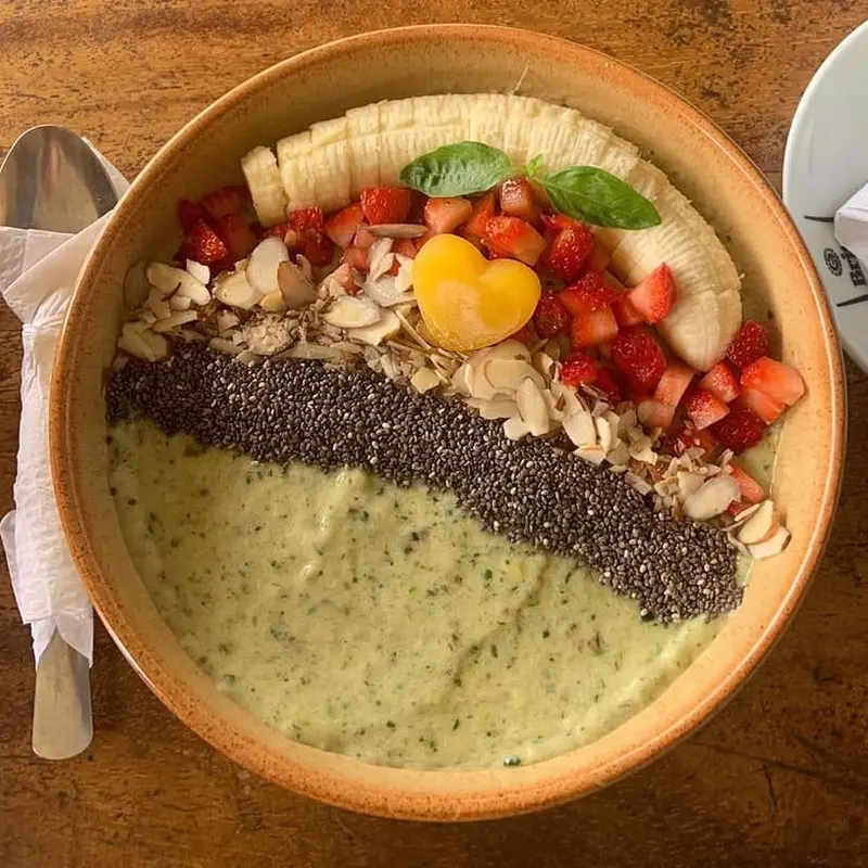 Bowl verde con banano, fresas, semillas de chía y almendras