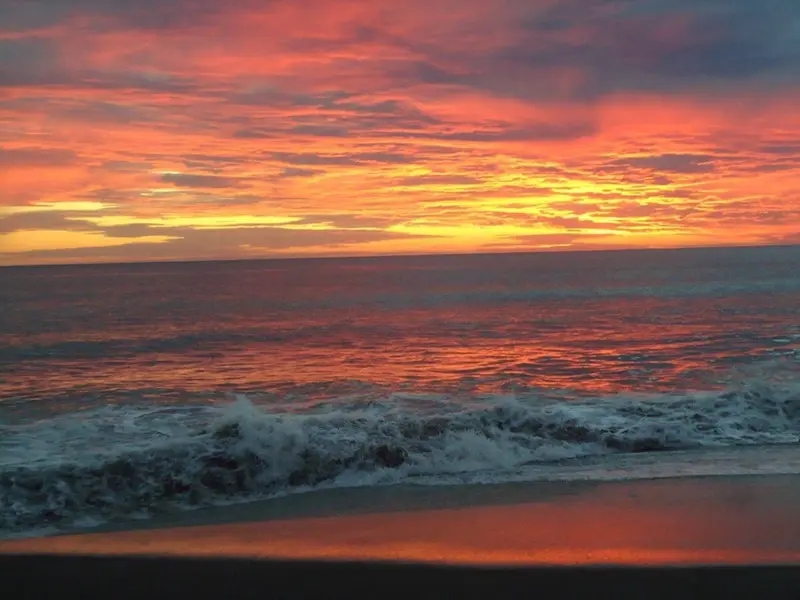 Cielo naranja y rojo sobre el mar al atardecer