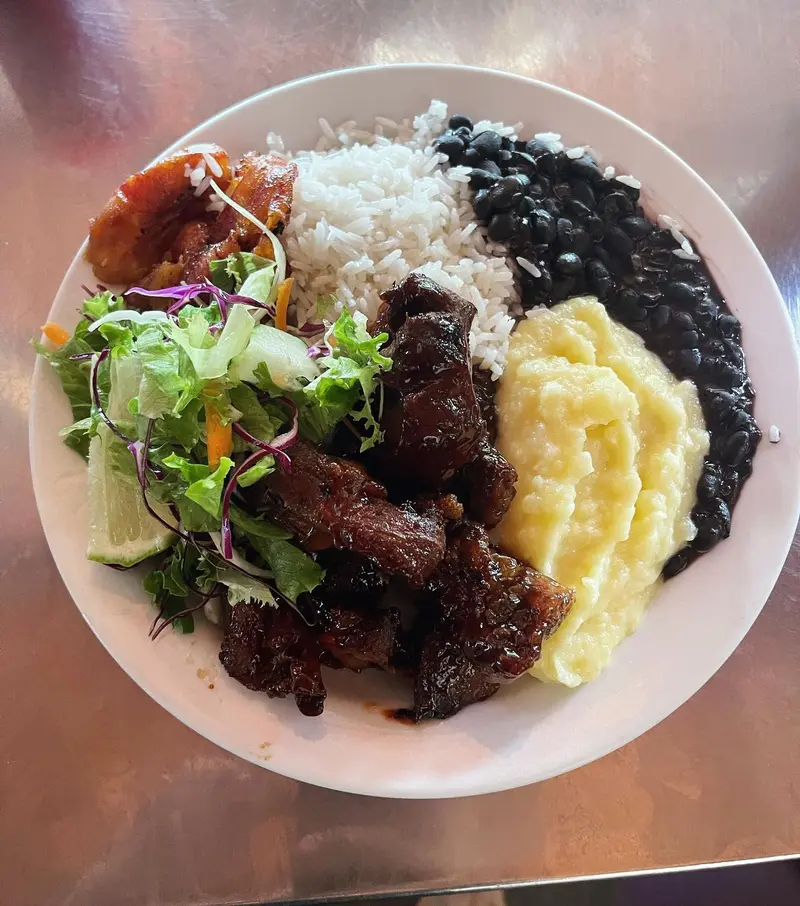 Casado con arroz, frijoles negros, puré de papa, ensalada y costilla en salsa BBQ