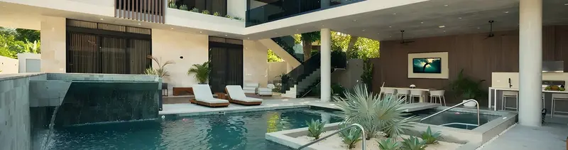 Piscina con cascada, jacuzzi, reposeras y terraza social de una villa