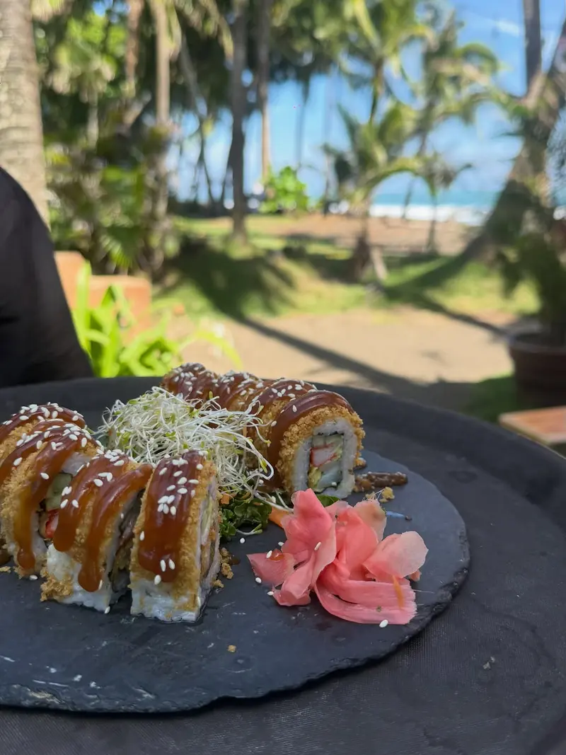 Sushi roll served with a beach and palm-tree view at Playa Hermosa