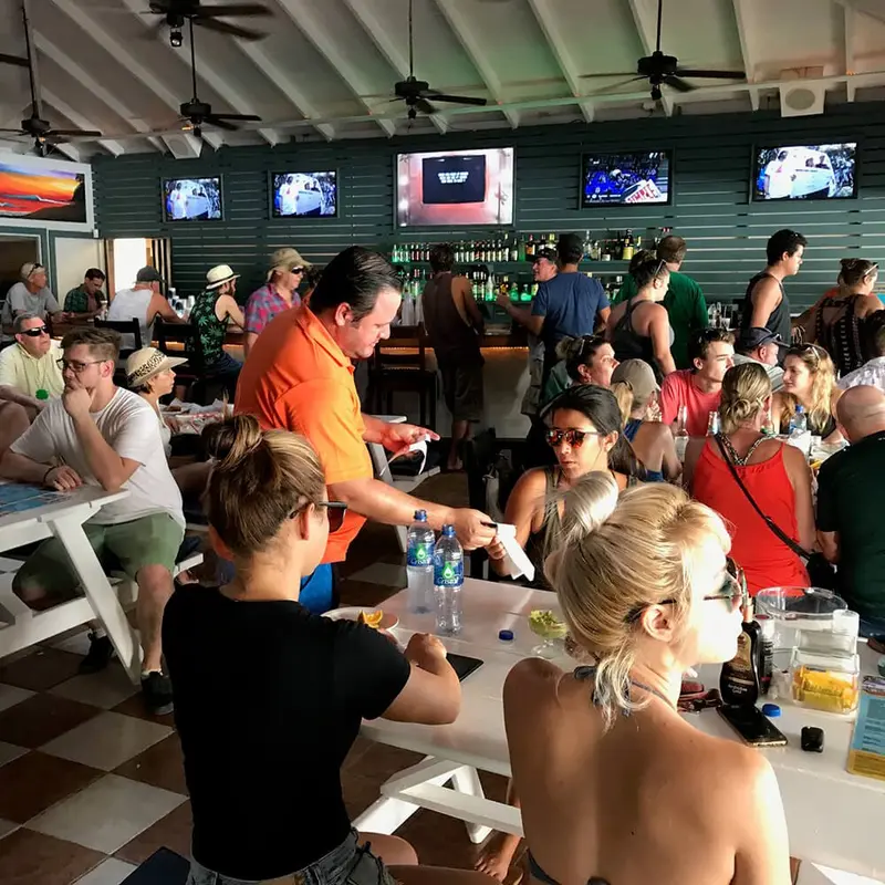 Hotel bar full of guests watching sports