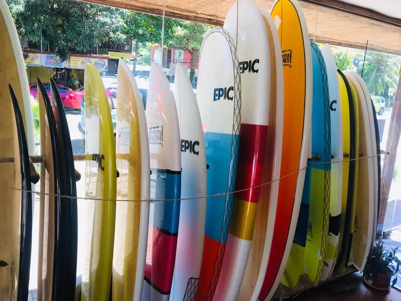 Fila de tablas de surf de colores en vertical dentro de la tienda
