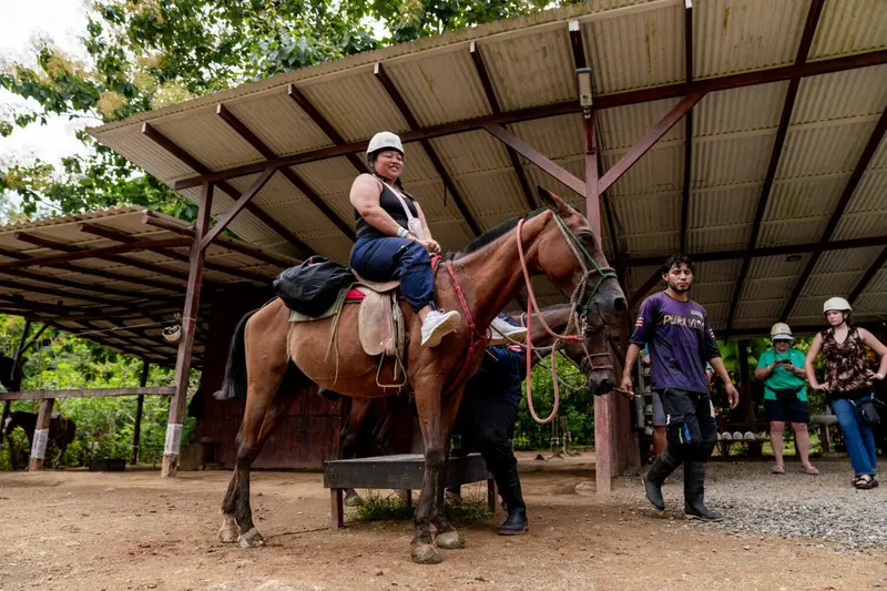 Visitante a caballo junto a los guías en el área de salida de las cabalgatas