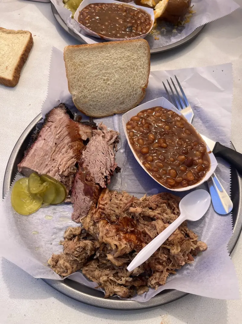 Brisket en lonjas y carne desmenuzada con frijoles horneados, pan blanco y pepinillos