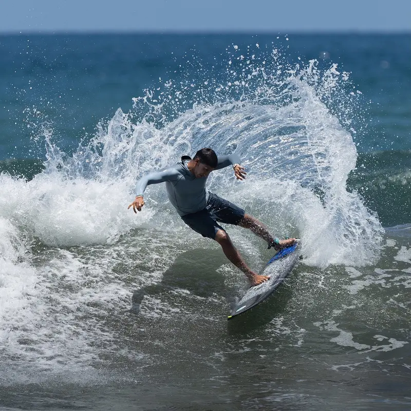 Surfer carving a turn with a big spray off a wave