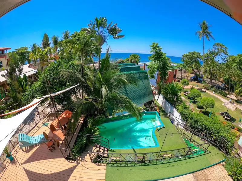 Vista aérea de la piscina, los jardines y el mar desde una terraza