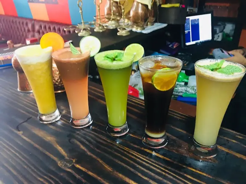 Cinco bebidas de la casa en vasos altos sobre la barra de madera