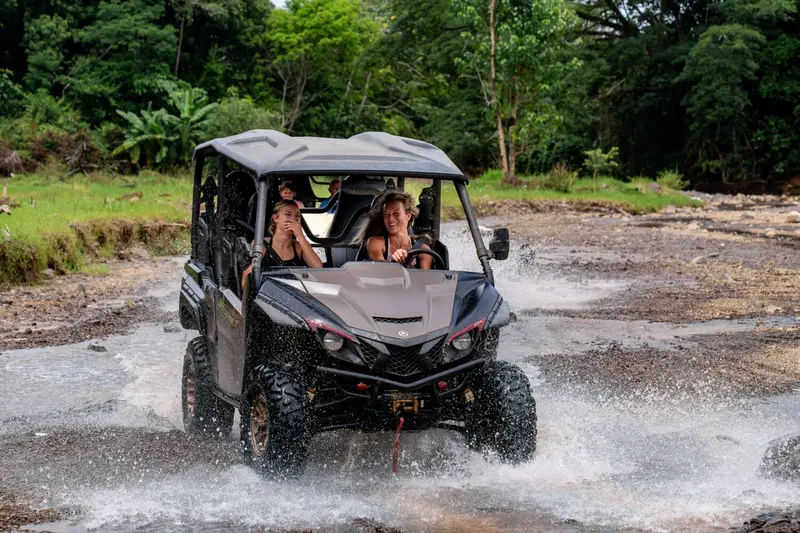 Buggy 4×4 con pasajeros salpicando agua al cruzar un río
