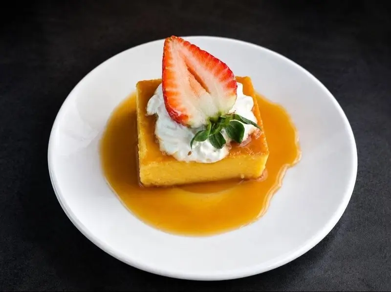 Postre de bizcocho con fresa, crema batida y salsa de caramelo